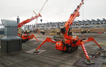 Работа мини-кранов на крыше здания